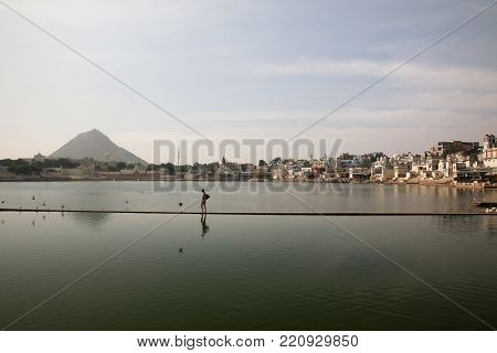 A traveler walking along the lake side in Pushkar