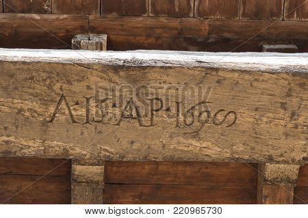 Italy, Florence - May 18 2017: the close up view of the old carved lettering on a wooden board on the Arnolfo Tower rooftop of Palazzo Vecchio on May 18 2017 in Florence, Italy.