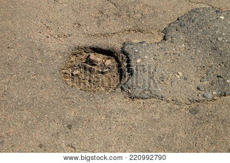 Close-up of damaged asphalt road with pothole
