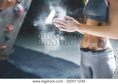 Woman Climber Is Chalking Hands With White Chalk Powder Before Climb In Indoor Climbing Gym. Woman G