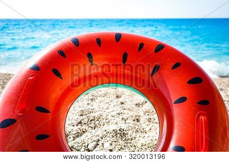 Bright Rubber Ring On The Beach Against The Sea
