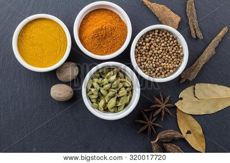 Spices In Little White Bowls On Black Slate Background - Indian Spice Top View Photo With Space For 