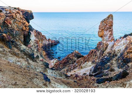 Exotic cliff rock, background sea 

Light brown color rocks and cliff, waves hitting the rocks