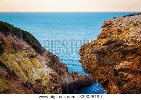 Exotic Cliff Rock, Background Sea 

Light Brown Color Rocks And Cliff, Waves Hitting The Rocks