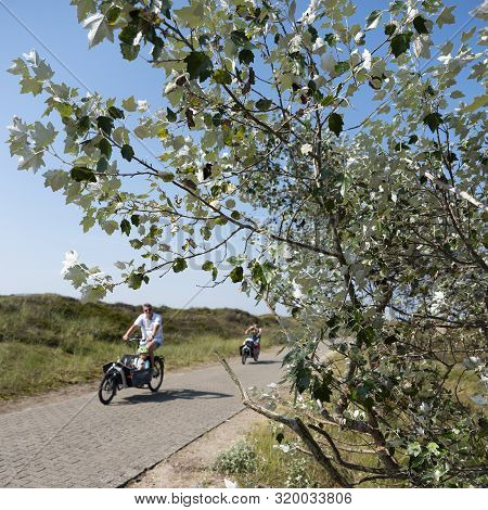 Norderney, Germany, 25 August 2019: People Enjoy Nature By Riding Bicycle On The German Island Of No