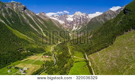 Aerial View On Geiranger Town, Harbor And Fjord In More Og Romsdal County In Norway Famous For His B