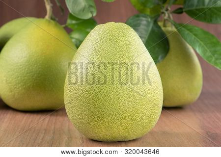 Fresh Peeled Pomelo, Grapefruit, Shaddock With Green Leaves On Dark Wooden Plank Table. Seasonal Fru