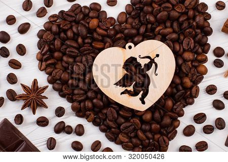 Heart Shaped Coffee Beans And Plywood Heart With Cupid. Roasted Coffee Beans Forming Heart Shape On 