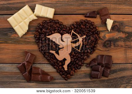 Heart Shaped Coffee Beans And Wooden Cupid. Shape Of Heart From Coffee Beans, Wooden Figure Of Amour