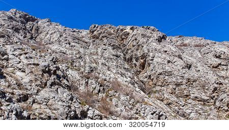 Rocks In The Mountains Against The Blue Sky.