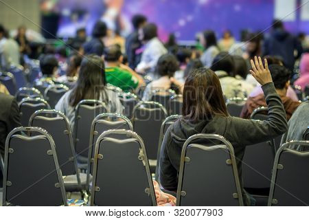 Speaker On The Stage With Rear View Of Audience In Put Hand Up Acton For Question In The Meeting Or 