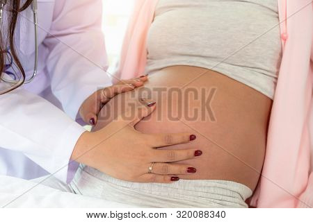 Beautiful Doctor Woman Checking Fetal Position By Touching Pregnant Woman Belly At Hospital. Beautif