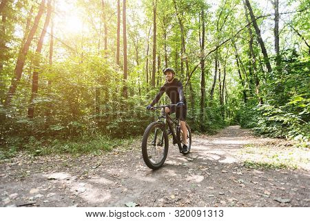 Young Male Cyclist Riding On Rorest Road, Active Summer Lifestyle, Copy Space