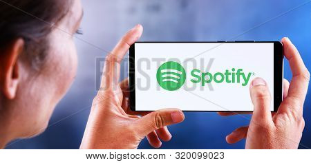 Poznan, Pol - Jul 10, 2019: Woman Holding Smartphone Displaying Logo Of Spotify, A Swedish Audio Str