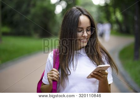 Pretty Student Girl Checking Classes Timetables Via Mobile Phone