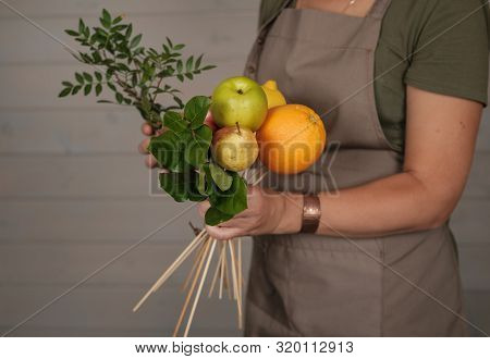 Woman Florist Collects Fruit Bouquet Of Fresh Apples, Orange, Lemon And Pear