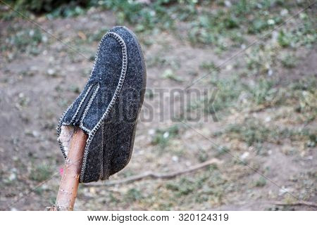 Gray Wool Shoe Hanging On Fence, Drying Shoes
