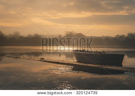 Sailing Boats On A Lake During A Frosty Winter Sunrise