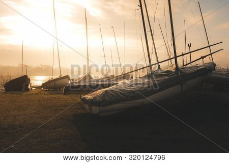 Sailing Boats On A Lake During A Frosty Winter Sunrise