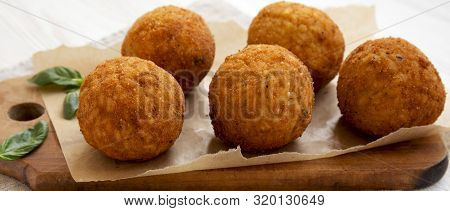 Homemade Fried Arancini With Basil On A Rustic Wooden Board, Side View. Italian Rice Balls. Close-up