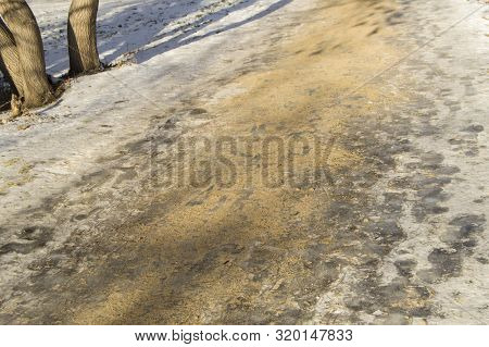 Slippery Winter Road, Sidewalk In The Park, Covered With Ice And Sprinkled With Sand. Anti-skid And 