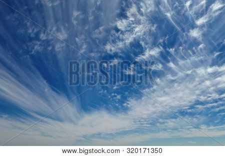 Wind Swept White Clouds And Blue Sky On A Sunny Day