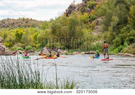Myhiya, Ukraine - August 17, 2019: Athletes Kayakers During Training On Whitewater And Man On Inflat