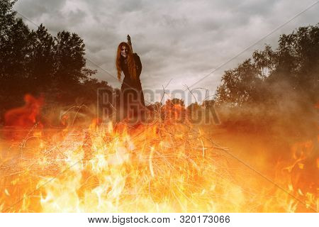 A portrait of an angry witch tied for incineration. Magic, dark force, spell. 