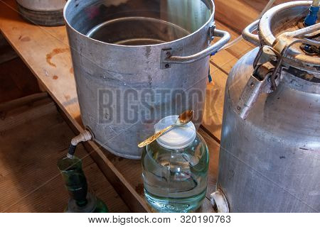 The Process Of Preparing Moonshine In A Village Bath In A Primitive Moonshine Distilling-apparatus. 