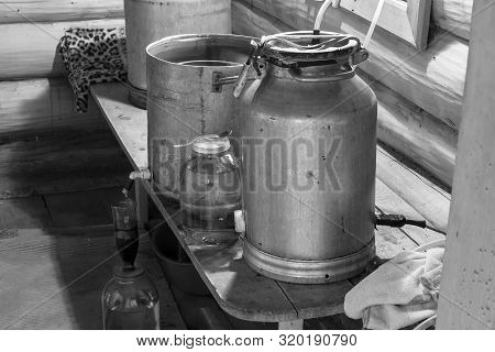 The Process Of Preparing Moonshine In A Village Bath In A Primitive Moonshine Distilling-apparatus. 