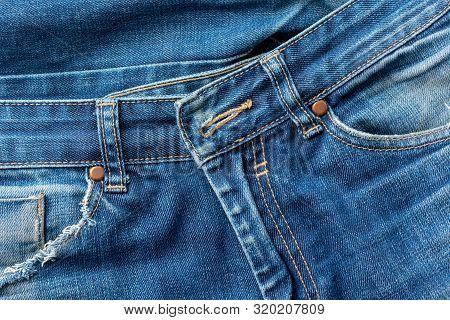 Close-up Of Old Torn Pocket Blue Jeans. Texture Or Background.