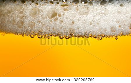 Fresh Blonde Beer Poured Into A Crystal Glass. Beer Makes A Lot Of Foam. Image With Beer In A Pleasa