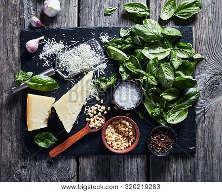 Fresh Basil Leaves, Grated Parmesan Cheese, Pine Nuts, Garlic, Pepercorns In A Bowl On A Rustic Wood
