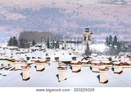 Bansko, Bulgaria Aerial Town Winter View With Houses Snow Roofs And St. Trinity Church Tower, Panora