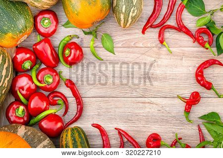 Top View Autumn Harves Vegetables. Pumpkin, Red And Green Hot Peppers On A Wood Background. Thanksgi