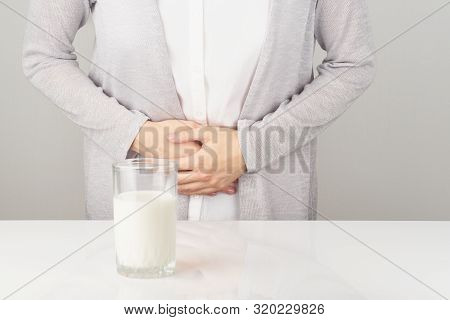 Woman Next To Glass Of Milk Having Bad Stomach Ache.