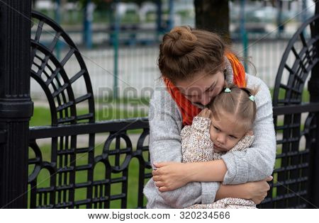 Young Woman Hugging A Child With Love And Tenderness
