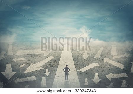 Doubtful Person, Hands On Hips, Choosing The Way As Multiple Arrows On The Road Showing A Mess Of Di