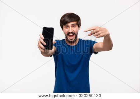 Good Looking Brunet Man In A Blue Shirt With Beard And Mostaches Shocked Looking At The Camera Point