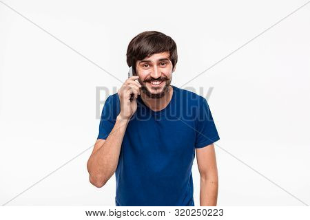 Handsome Brunet Man In A Blue Shirt With Beard And Mostaches Smiling Speaking On The Smartphone Stan