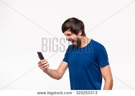 Displeased Handsome Brunet Man In A Blue Shirt With Beard And Mostaches Shocked Looking At The Scree