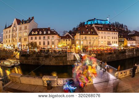 View Of Lively River Ljubljanica Bank In Old City Center Decorated With Christmas Lights At Dusk. Ol