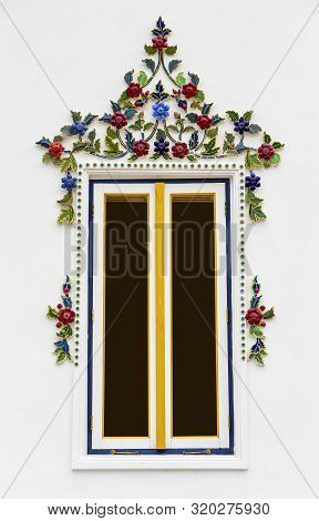 Windows Are Adorned With Stucco Molding With Flower Orament And Painted White Walls.