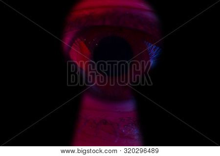 Human Eye Looking Through A Keyhole. Halloweeen Concept