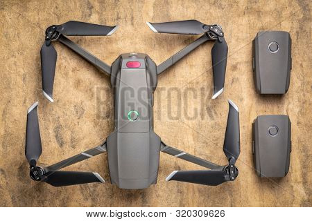 Fort Collins, CO, USA - March 10, 2019  Overhead view of DJI Mavic 2 pro drone with two spare batteries against textured handmade paper.