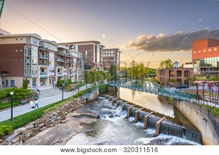 Downtown cityscape of of Greenville, South Carolina, USA on the Reedy River at dusk.