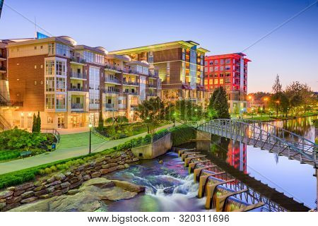 Downtown cityscape of of Greenville, South Carolina, USA on the Reedy River at dusk.