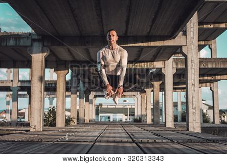 A Sportsman In The High Jump. A Man In Jump, Symmetrical Composition. Athlete In The Jump At The Rus