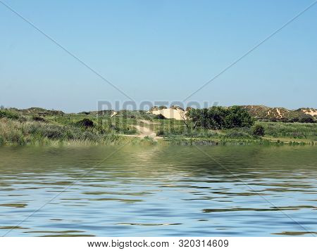 A View From The Sea Of A Winding Path Through Sand Dunes And Grass On The Merseyside Coast Near Form