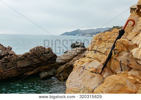 On A Rainy Autumn Day On The Seaside Cliffs A Forgotten Black Umbrella. Crimea, Malorechenskoye. Bea